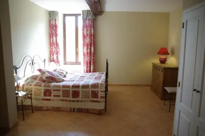 a bedroom with a bed and a window at Le Relais Du Grand Logis in Mirabeau