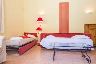 a hotel room with two beds and a table at Le Relais Du Grand Logis in Mirabeau