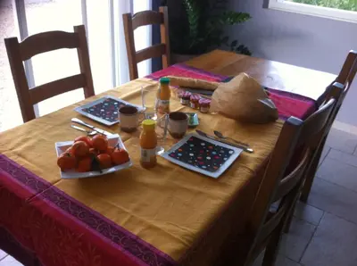 a wooden table with food and drinks and fruit on it at Campagne Cérès in Le Puy-Sainte-Réparade