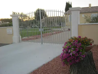 a gate with a bunch of flowers in front of it at Le Jardin des Tourterelles in Robion en Luberon