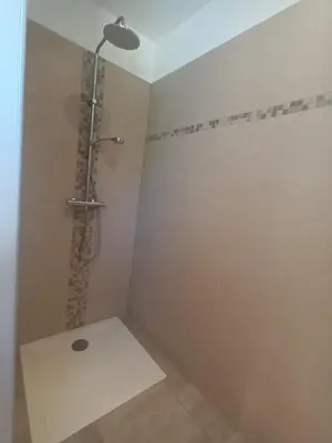 a bathroom with a shower with a shower head at Le Jardin des Tourterelles in Robion en Luberon