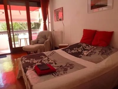 a bedroom with a bed with a red suitcase on it at Apartment Les Muriers Blancs in Aix-en-Provence