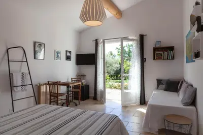a bedroom with a bed and a dining room with a table at Chambre d'hôtes le Mirail in La Motte-dʼAigues