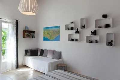 a living room with a white couch and a window at Chambre d'hôtes le Mirail in La Motte-dʼAigues