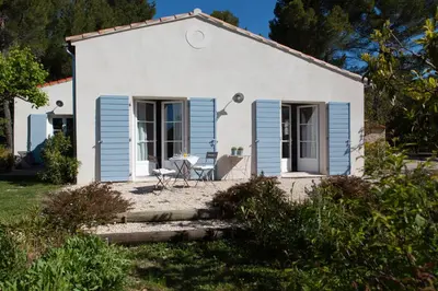 a small white house with blue shutters at Chambre d'hôtes le Mirail in La Motte-dʼAigues