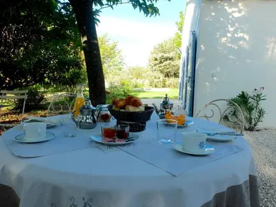 a table with a white table cloth with a basket of fruit at Chambre d'hôtes le Mirail in La Motte-dʼAigues