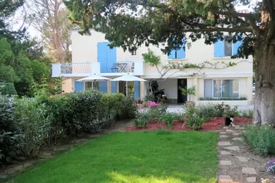 a house with a garden and a cat in the yard at La Luberonne in Lourmarin