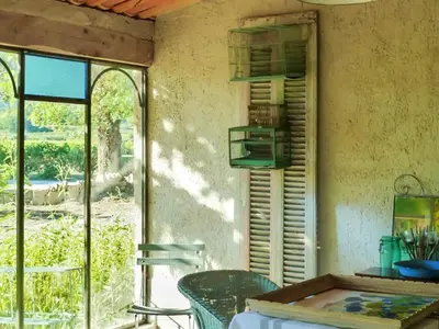 a dining room with a table and a window at Maison charmante à Oppède avec piscine partagée in Oppède