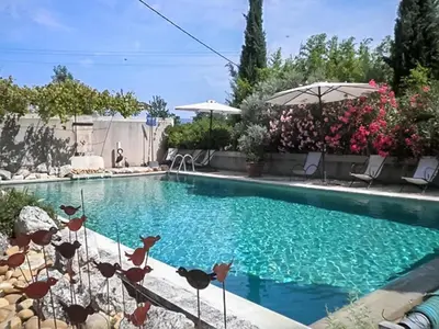 a swimming pool with blue water in a yard at Maison charmante à Oppède avec piscine partagée in Oppède