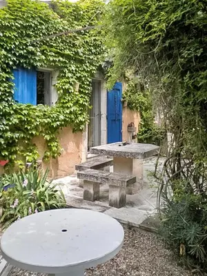 a picnic table and bench in front of a building at Maison charmante à Oppède avec piscine partagée in Oppède