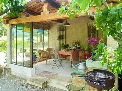 a screened in patio with a table and chairs at Maison charmante à Oppède avec piscine partagée in Oppède
