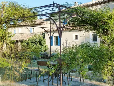 a garden with tables and chairs in front of a building at Maison charmante à Oppède avec vue sur la montagne in Oppède