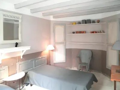 a bedroom with a bed and a table and chairs at Appartement accueillant avec piscine à Oppède 70 m², vue montagne in Oppède