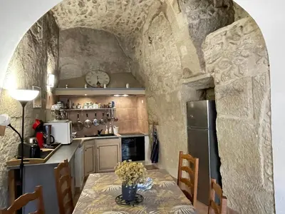 a kitchen with a table with flowers on it at Luberon maison de village entière 2 à 6 personnes in Cabrières-dʼAigues