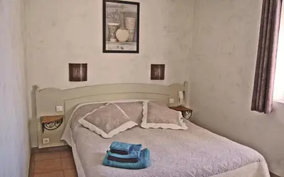 a bedroom with a bed with a blue bag on it at Cyprès du Paradis à Gordes in Gordes
