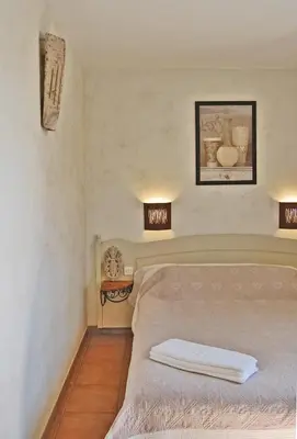 a bedroom with a bed and two lights on the wall at Cyprès du Paradis à Gordes in Gordes