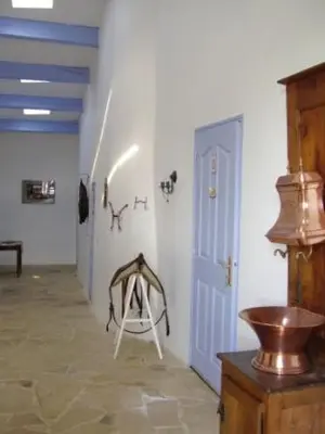 a room with a white wall with a door and a table at Le Petit Labouret in Revest-du-Bion