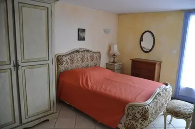 a bedroom with a bed and a dresser and a mirror at Le Petit Labouret in Revest-du-Bion