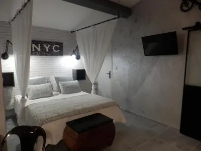 a bedroom with a bed and a television in a room at Mas les vieux chênes in Lambesc