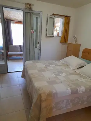 a bedroom with a bed and a sliding glass door at Gîte chez Cécile à Lagnes, aux portes du Luberon in Lagnes
