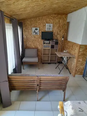 a room with a bench and a table and a television at Gîte chez Cécile à Lagnes, aux portes du Luberon in Lagnes