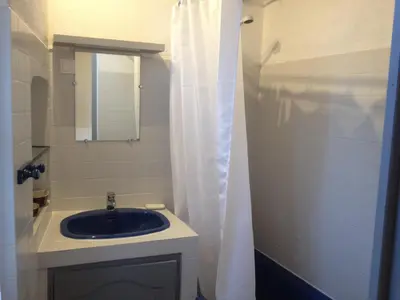 a bathroom with a sink and a white shower curtain at Appartement le Platane in Pertuis