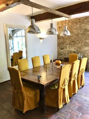 a dining room with a wooden table and yellow chairs at Le Mas de Trévouse in Saint-Saturnin-lès-Avignon