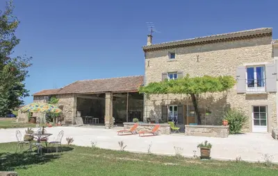 a large stone building with a table and chairs at Cozy Home In Pernes Les Fontaines in Pernes-les-Fontaines