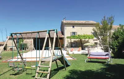 a playground with two swings in a yard at Cozy Home In Pernes Les Fontaines in Pernes-les-Fontaines