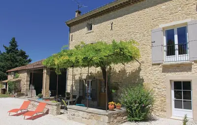 a stone building with a tree in front of it at Cozy Home In Pernes Les Fontaines in Pernes-les-Fontaines