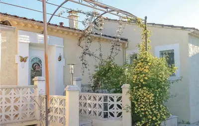 a white house with a white fence and a bush at Beautiful Home In Maubec in Maubec