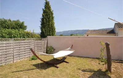 a hammock in a yard next to a fence at Beautiful Home In Maubec in Maubec