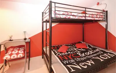 a bedroom with a bunk bed with a red wall at Beautiful Home In Maubec in Maubec