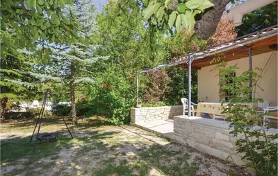 a garden with a bench and a swing at Cozy Home In Crillon Le Brave With Wifi in Crillon-le-Brave