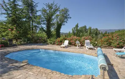 a swimming pool with two chairs and a table at Awesome Home In Crillon Le Brave in Crillon-le-Brave