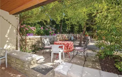 a patio with a table and chairs in a garden at Awesome Home In Crillon Le Brave in Crillon-le-Brave