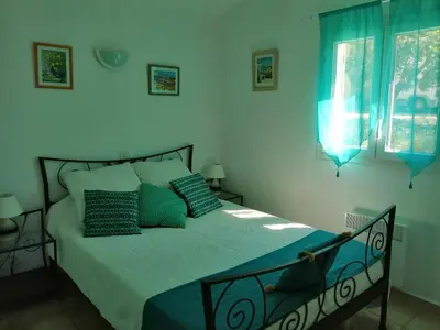 a bedroom with a large bed with blue pillows at L'oustau des euses in Bédoin
