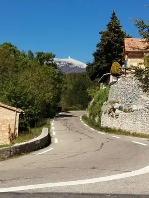 an empty road with a mountain in the background at L'oustau des euses in Bédoin