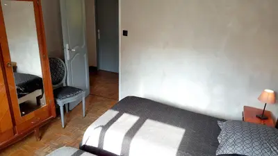a bedroom with a bed and a chair and a mirror at Maison de charme avec piscine privée à Velleron in Velleron
