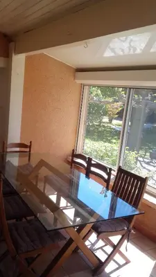 a glass table and chairs in a room with a window at Maison de charme avec piscine privée à Velleron in Velleron