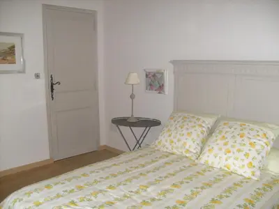 a bedroom with a bed and a table with a lamp at Les grands pins in Saint-Andiol