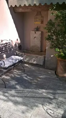 a bench sitting on a patio next to a building at Les grands pins in Saint-Andiol