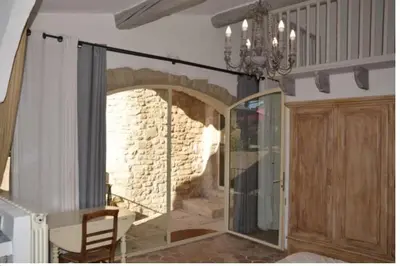 a dining room with a glass door and a stone wall at Maison d'artiste à Bonnieux in Bonnieux