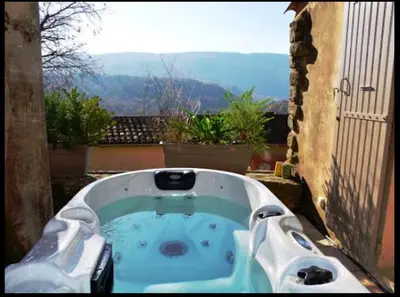 a jacuzzi tub on a balcony with a view at Maison d'artiste à Bonnieux in Bonnieux