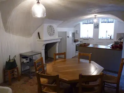 a dining room with a wooden table and a kitchen at Maison d'artiste à Bonnieux in Bonnieux