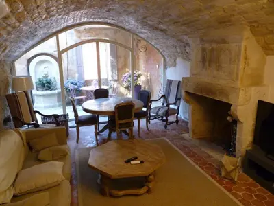 a living room with a table and a fireplace at Maison d'artiste à Bonnieux in Bonnieux