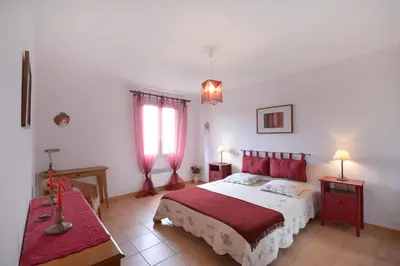 a bedroom with a large bed with red pillows at Cerise en Provence in Venasque