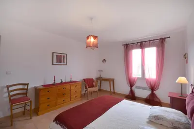 a bedroom with a bed and a dresser and two windows at Cerise en Provence in Venasque