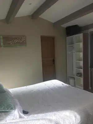 a bedroom with a white bed and a closet at L'atelier des Coudelières in Le Thor