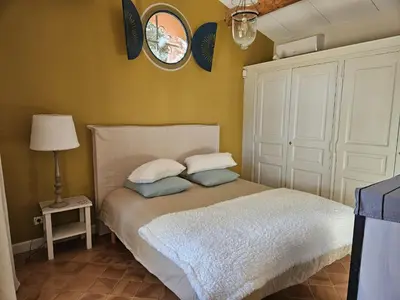 a bedroom with a bed with two pillows and a mirror at La Petite Yolande in Aix-en-Provence